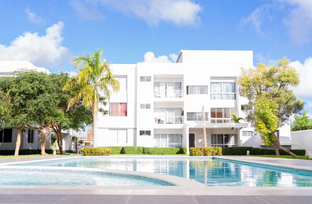 White apartments surrounding a shared outdoor pool